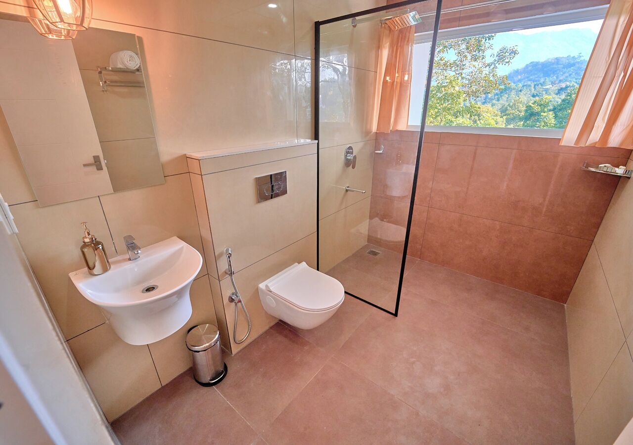 Un bagno con lavandino, servizi igienici e box doccia in vetro.
