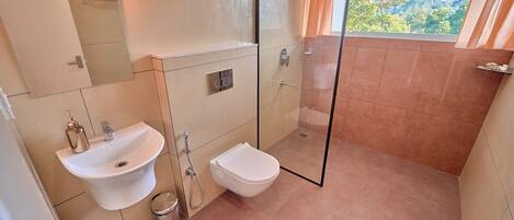 Un bagno con lavandino, servizi igienici e box doccia in vetro.