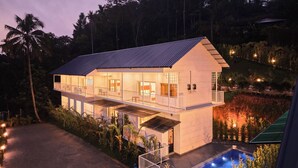 A two-story house with a balcony, a swimming pool, and a garden. - Ice Cliff Munnar by VOYE HOMES (Munnar)