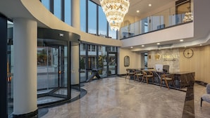 A spacious lobby with a reception desk, seating area, and a large chandelier. - The Komana Dardanelles (Çanakkale)