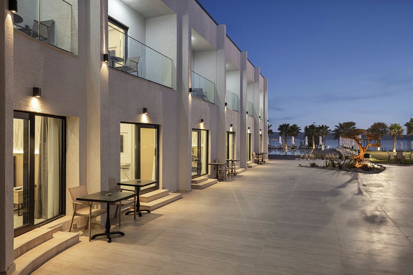 Een modern hotel met terras, een zwembad en uitzicht op de oceaan.