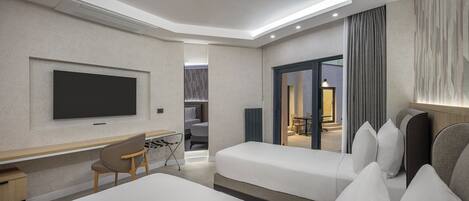 Habitación de hotel moderna con televisión de pantalla plana, escritorio, silla, cama y vista al área exterior.