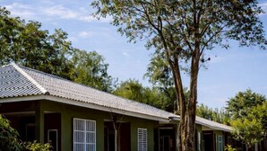 A building with a tiled roof, green walls, and a white fence. - Na Ville Resort (Ton Pho)