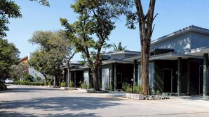 A street view with a row of modern buildings, trees, and a clear sky. - Na Ville Resort (Ton Pho)