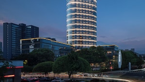 Un moderno edificio de gran altura con una fachada curva distintiva y ventanas iluminadas.