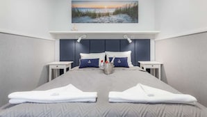 A hotel room with a large bed, two bedside tables, a headboard, and a painting of a beach scene. - Comfortable Apartment | Pool | Close to the Beach (Pobierowo)