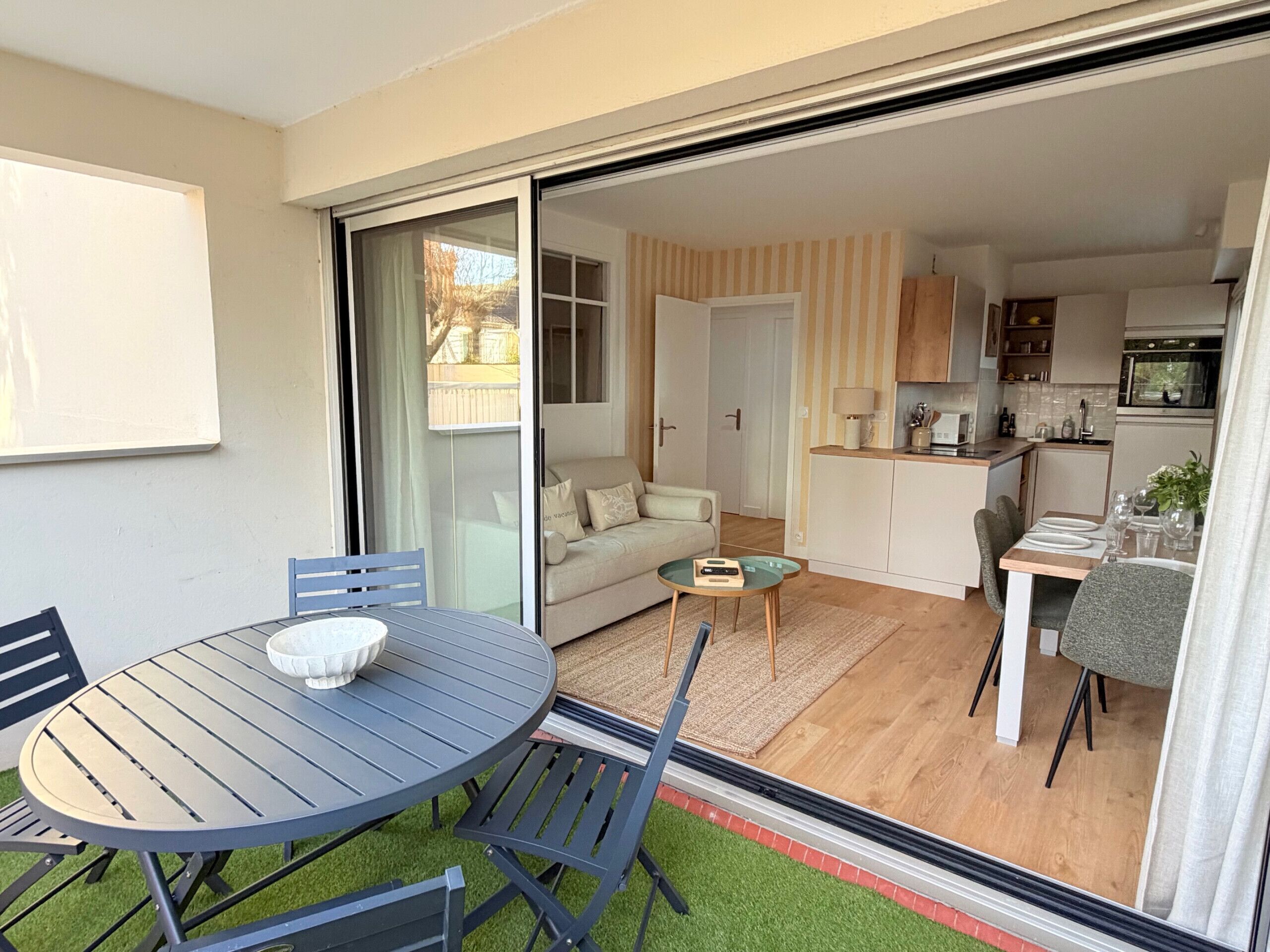 Um apartamento moderno com área de refeições, um sofá e uma cozinha.