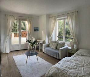 Une chambre à coucher avec un lit, un bureau, une chaise et une fenêtre avec des rideaux.