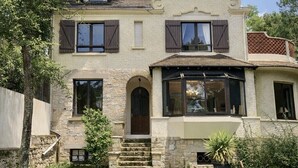 A two-story house with a stone facade, a central entrance with steps, and a large window on the second floor. - KER MARINE : Villa La Baule (La Baule-Escoublac)