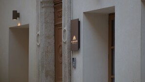 A building entrance with an ornate archway, a wooden door, and a sign with the name 'NIZZO GIGLI'.