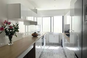 Eine moderne Küche mit Kochinsel, Fenster und Heizkörper.