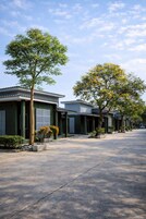 Una hilera de casas modernas con entrada pavimentada y árboles al frente.
