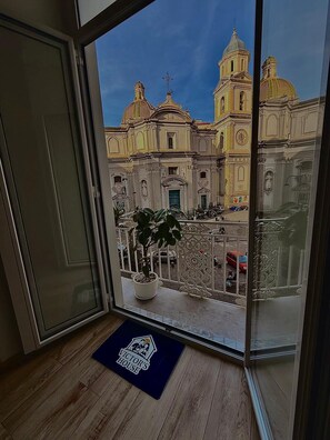 Un balcó amb vista a un edifici històric amb cúpules i un rellotge.
