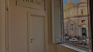 A hallway with a sign reading 'VICTOR'S HOUSE,' a door, and a window with a view of a building. - Cozy vacation home in the heart of the historic center of Naples (Napoli)