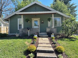A single-story house with a front porch, a mailbox, and a small garden with stepping stones leading to the entrance. - The Dragonfly at Hillside: Easy Getaway in Btown (Bloomington)