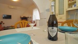 Una bottiglia di Prosecco Valdobbiadene su un tavolo con piatti blu e bicchieri da vino.