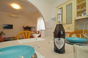 Eine Flasche Valdobbiadene Prosecco auf einem Tisch mit blauen Tellern und Weingläsern.