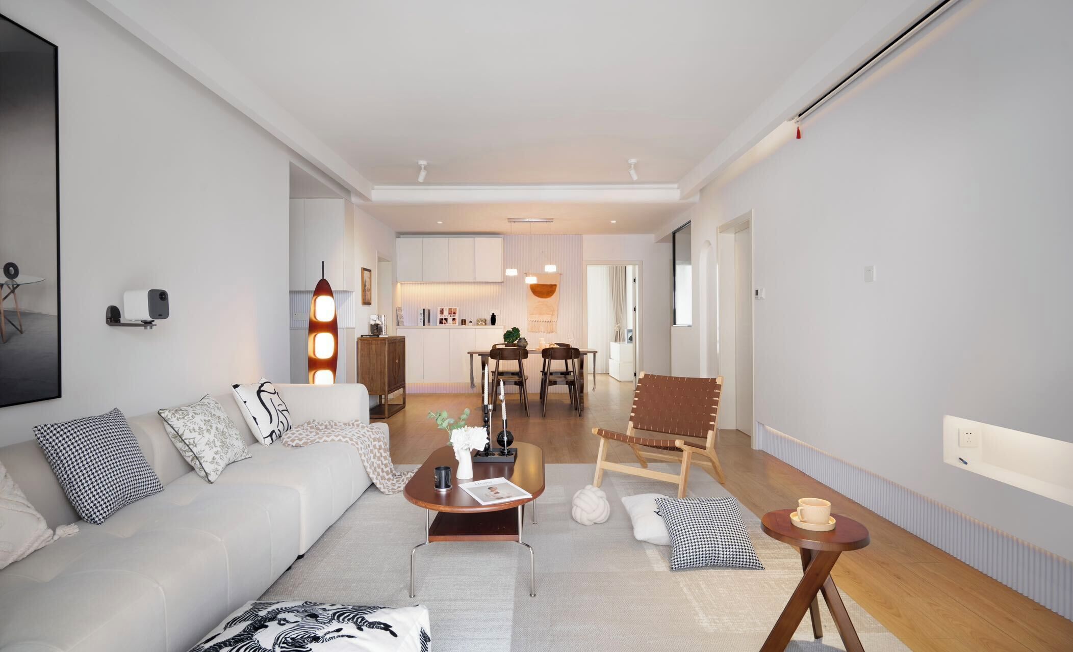 Ein modernes Wohnzimmer mit einer Couch, einem Couchtisch und einem Essbereich im Hintergrund.