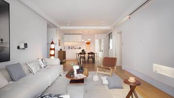 Ein modernes Wohnzimmer mit einer Couch, einem Couchtisch und einem Essbereich im Hintergrund.