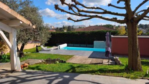 A backyard with a swimming pool, a pergola, and a tree. - Villa "Laurent" with Private Pool Near Lyon (Charly)