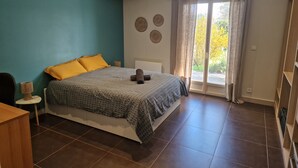 A bedroom with a bed, a nightstand, a lamp, a window with curtains, and a view of the outdoors. - Villa "Laurent" with Private Pool Near Lyon (Charly)