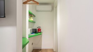A small, narrow room with a green shelf, a red kettle, and a white air conditioner. - Palazzo Ferrara Rooms by Wonderful Italy (Palermo)
