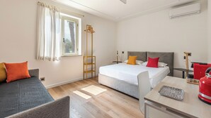 A hotel room with a bed, a desk, a chair, a wardrobe, and a window. - Palazzo Ferrara Rooms by Wonderful Italy (Palermo)