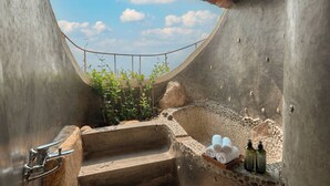 A stone bathtub with steps, a small garden, and a view of the sky. - Ibala Hotel & Spa (Bac Nha Trang)