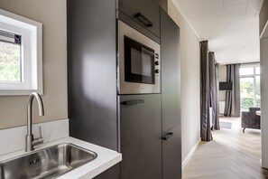 A modern kitchen with a built-in microwave, a stainless steel sink, and a window.
