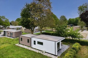 Un quartier résidentiel moderne composé de maisons individuelles, dotées d’une toiture plate et d’une pelouse bien entretenue.