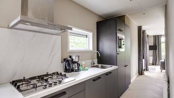 Une cuisine moderne équipée d’une cuisinière à gaz, d’une machine à café et d’une fenêtre.