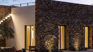 Un bâtiment moderne avec une façade en pierre, de grandes fenêtres et un escalier.