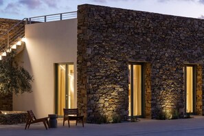 A modern building with a stone facade, large windows, and a staircase. - Villa Calisto – A Sunset Sanctuary (2524+VXR Paros, Greece)
