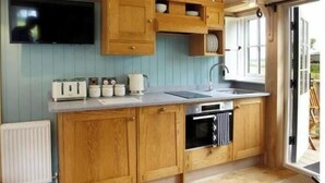 A kitchen with wooden cabinets, a built-in oven, a sink, and a window.