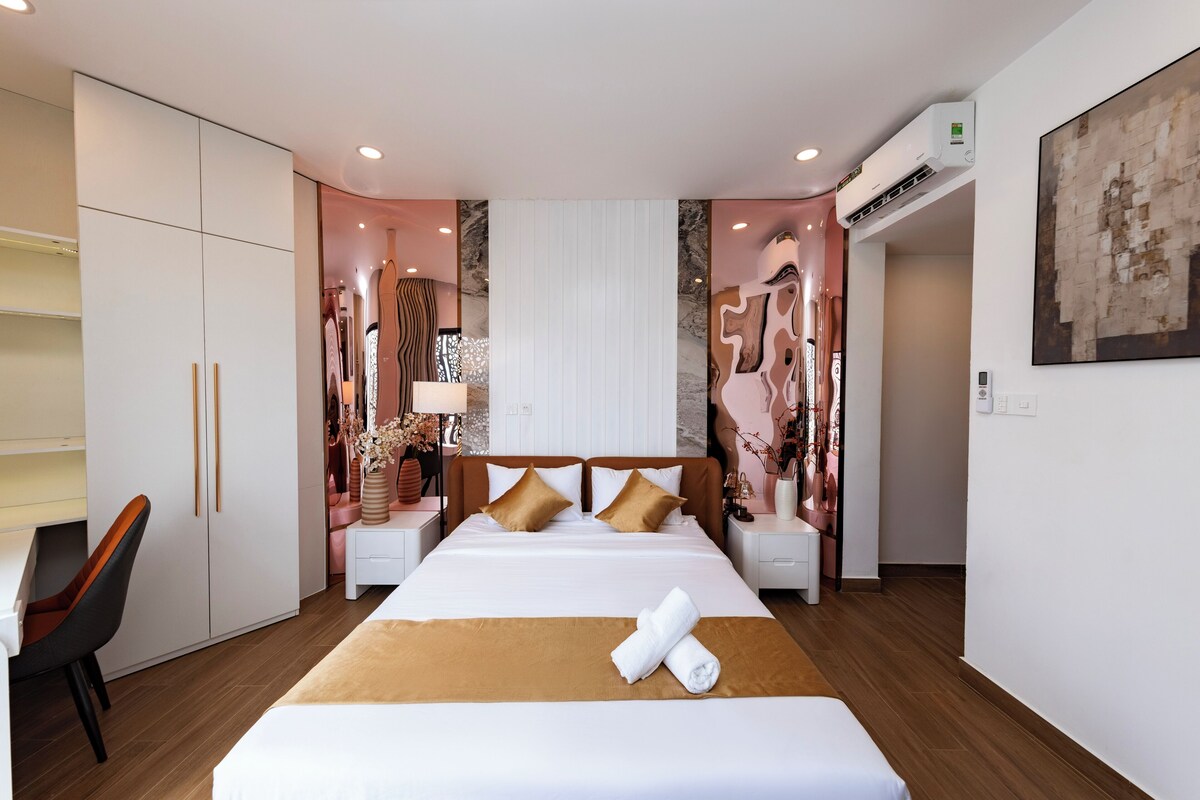 Ein Hotelzimmer mit Bett, Nachttischen, einem Kleiderschrank und einer Klimaanlage.