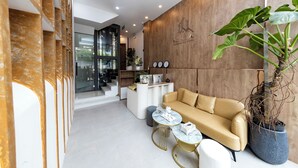 A modern living room with a sofa, coffee table, and potted plant. - HomeAi Apartment - Binh Thanh near LM81 (Ho Chi Minh City)