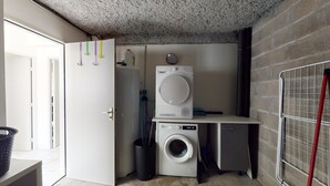 A laundry room with a washing machine, a dryer, and a utility sink.