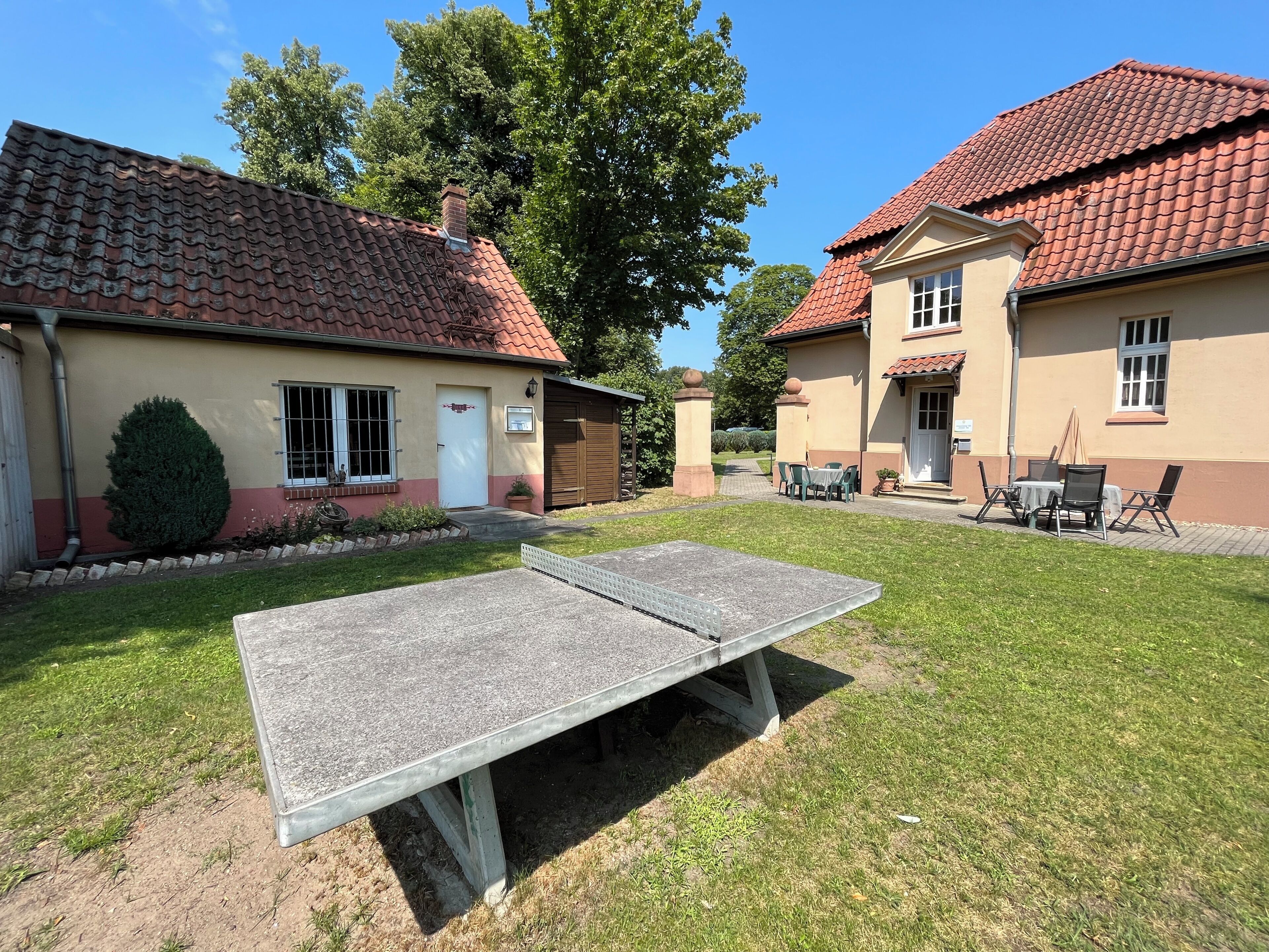 A residential property with a paved patio, a small table, and chairs.