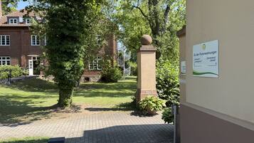 A courtyard with a brick building, a stone staircase, and a sign indicating directions to different parts of the property.