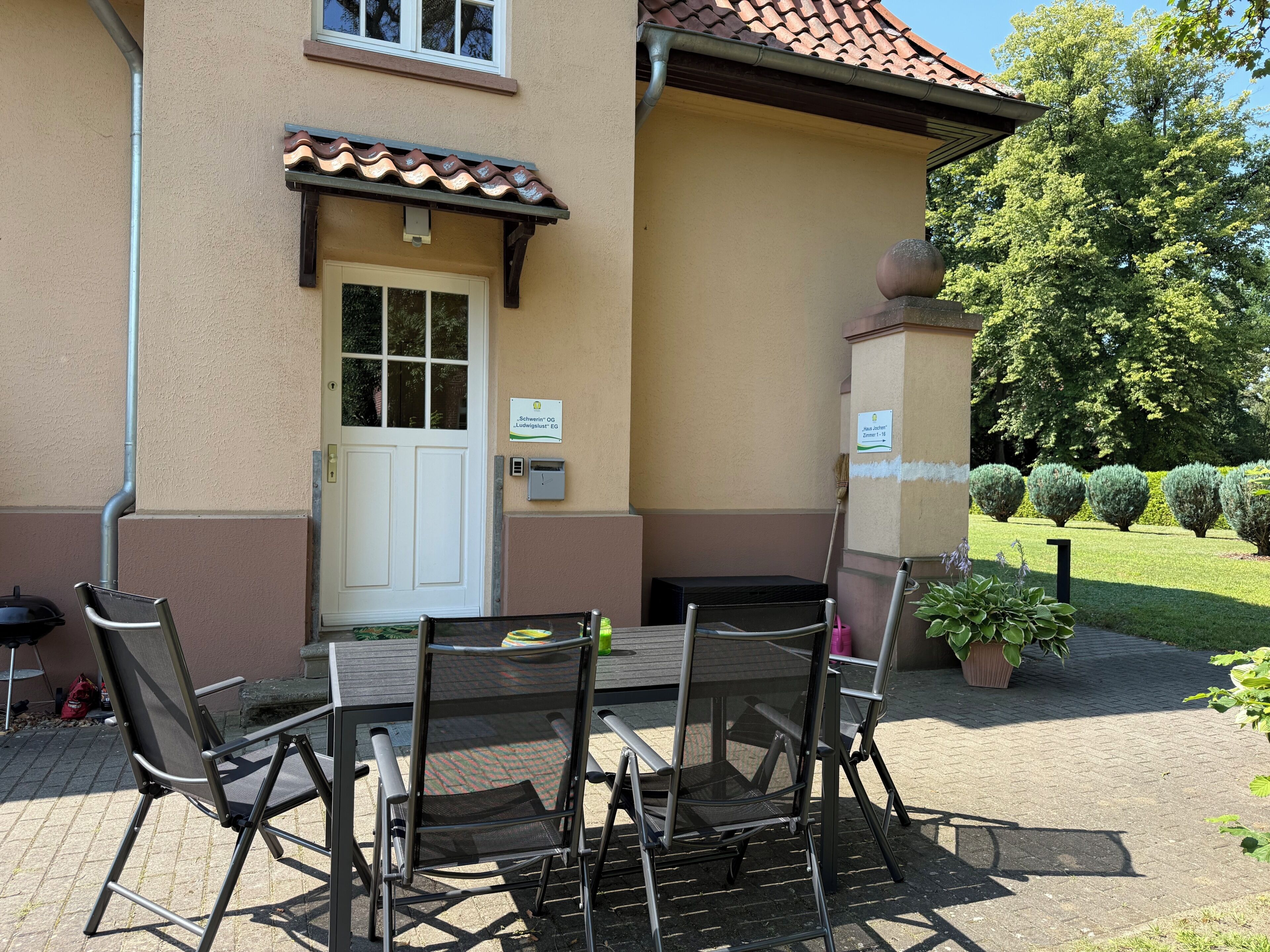A patio with a table and chairs, a door, and a sign indicating a guest room.