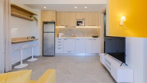 Een moderne keuken met witte kasten, een ingebouwde magnetron en een koelkast.
