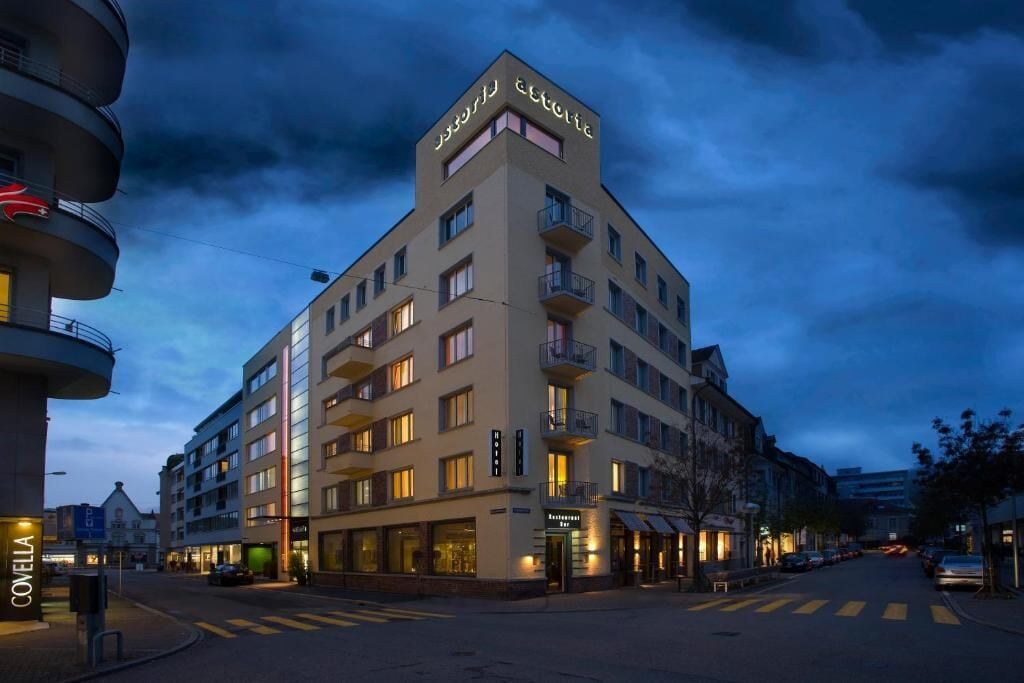 Un hôtel à plusieurs étages doté de balcons, d’un restaurant et d’une entrée bien visible.