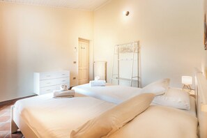 Une chambre d’hôtel avec deux lits, une commode, un radiateur et un miroir.