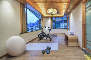 Ein Fitnessraum mit Trainingsgeräten, einer Yogamatte und einem großen Trainingsball.