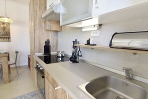 A modern kitchen with a stainless steel sink, wooden cabinets, and a built-in oven. - Comfortable stay near Umag center (Umag)