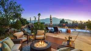 Um terraço no telhado com área de estar ao ar livre, lareira e piscina.