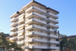 A multi-story hotel with balconies, a flat roof, and a clear sky. - Lovely sea view apartment (Lignano Sabbiadoro)