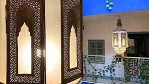 A traditional interior with ornate wooden screens and a hanging lantern. - Paradise Riad in Marrakech Medina with Rooftop Terrace, sleeps 12 (Marrakech)