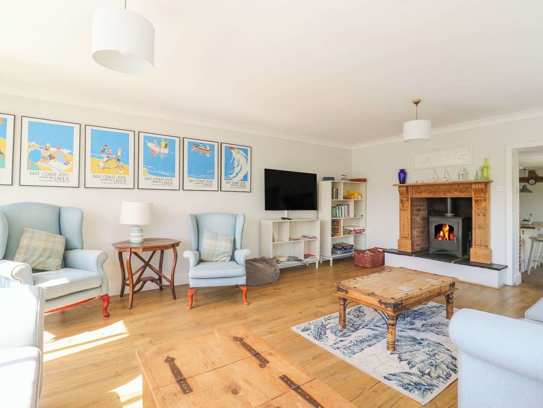A living room with a fireplace, a television, and a bookshelf.