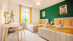 Een hotelkamer met twee bedden, een bureau en een stoel.